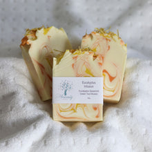 Load image into Gallery viewer, Three bars of soap with a label on a textured surface