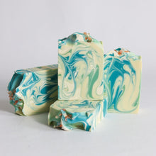 Load image into Gallery viewer, Three bars of marbled soap with green and white swirls on a light gray background