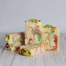 Load image into Gallery viewer, Colorful swirled soap bars on a light wooden surface with a neutral background