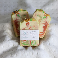 Load image into Gallery viewer, Colorful swirled soap bars with a label on a textured surface