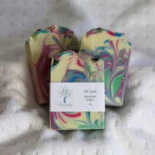Load image into Gallery viewer, Colorful marbled soap bars with a label on a textured surface