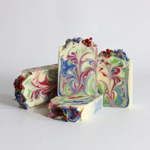 Load image into Gallery viewer, Colorful swirled soap bars with floral elements on a light gray background
