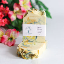 Load image into Gallery viewer, Marbled soap bar with a label in front of flowers