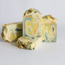 Load image into Gallery viewer, Three bars of marbled soap with yellow and blue swirls on a light gray background