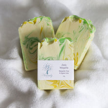 Load image into Gallery viewer, Three bars of soap with green and yellow swirls on a white fabric background