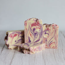 Load image into Gallery viewer, Three bars of marbled soap with pink, purple, and white swirls on a light wooden surface.
