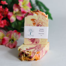 Load image into Gallery viewer, Marbled soap bar with a visible brand label against a floral background
