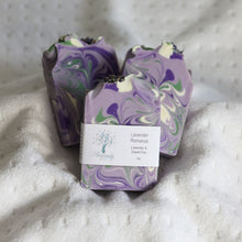 Load image into Gallery viewer, Two bars of soap with a marbled design on a textured surface
