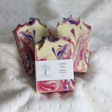 Load image into Gallery viewer, Three marbled soap bars with a label on a textured white surface
