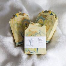 Load image into Gallery viewer, Marbled soap bars with a label on a white fabric background
