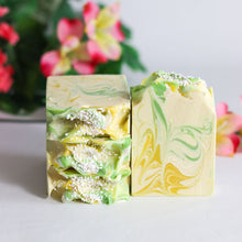 Load image into Gallery viewer, Two swirled soap bars with green and yellow colors on a light background.
